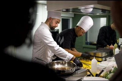 Traiteur Romain Merlet Traiteur Bussy-Saint-Georges #2 Deux chefs cuisiniers en tenue blanche préparent des plats dans une cuisine professionnelle éclairée.