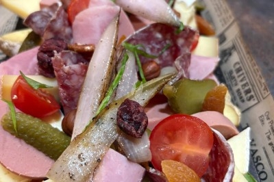 Traiteur Les Very Traiteur Marseille 11 #5 Plateau de charcuterie et fromages avec cornichons, tomates cerises, oignons marinés et fruits secs, présenté sur du papier…