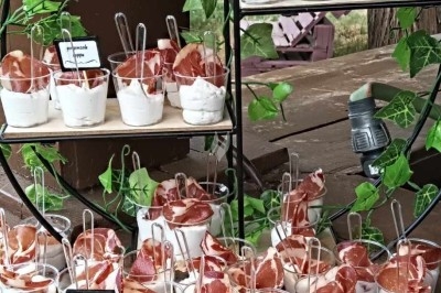 Plateau de verrines au jambon et fromage frais, accompagné de mini-burgers au sésame, présenté sur une table en bois.