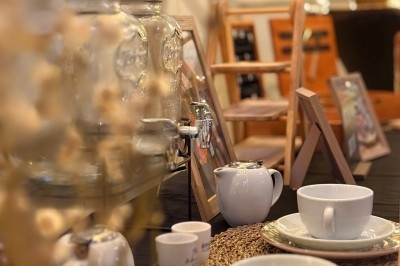 Table dressée avec des tasses, théières et distributeurs de boissons, décorée dans un style chaleureux et rustique.