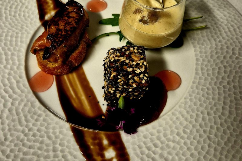 Traiteur La Petite Cuillère Traiteur Theix #5 Assiette dressée : tranche poêlée sur pain grillé, bloc enrobé de graines sur sauce brune et mousse en verrine.