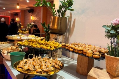 Buffet de réception avec assortiment de bouchées salées, samoussas, mini-burgers et sauces, dans un cadre lumineux et…