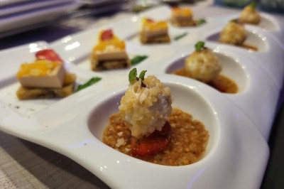 Assortiment de bouchées gastronomiques présentées sur un plateau blanc, avec des garnitures variées.