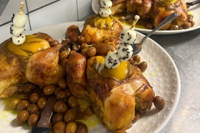 Poulet aux Olives Poulets rôtis garnis de fruits et accompagnés d'olives, présentés sur une assiette blanche.