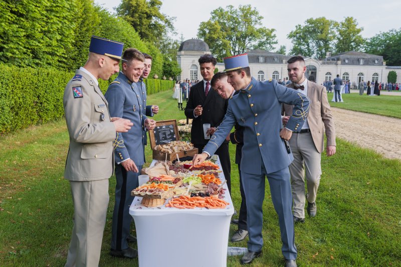 Traiteur Le 17.45 Vieux Lille Lille #4 Militaires en uniforme autour d'une table de buffet froid en plein air, parc avec château en arrière-plan.